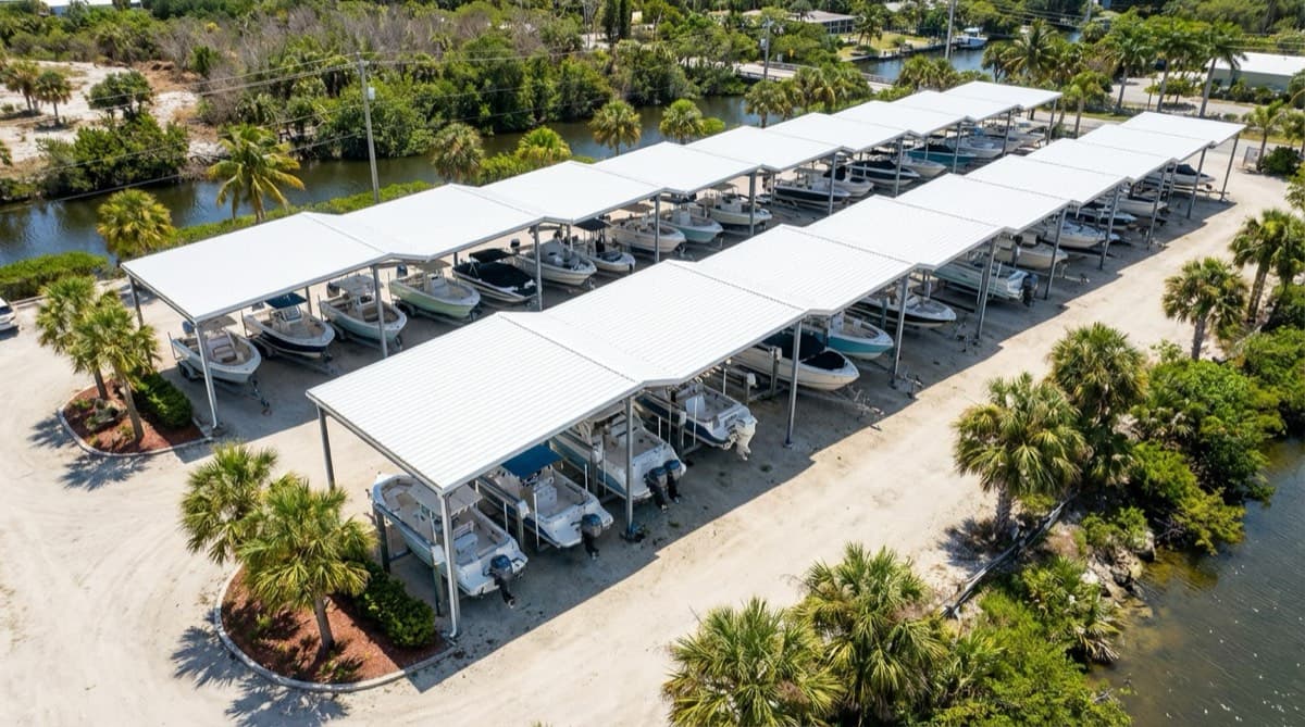 Row of covered boat storage bays with white metal canopy roofs