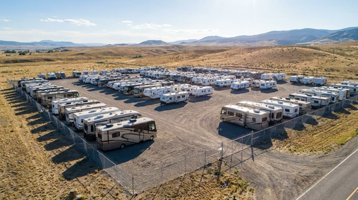 Aerial view of an outdoor RV storage lot with motorhomes and trailers in rows